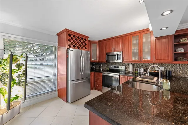 a kitchen with stainless steel appliances granite countertop a refrigerator and a sink
