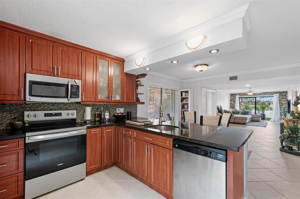 11927 Southwest 13th Court Davie, FL 33325 - Photo 19 of 41 a kitchen with stainless steel appliances a stove sink microwave and cabinets