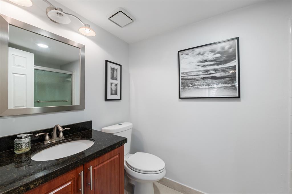 11927 Southwest 13th Court Davie, FL 33325 - Photo 21 of 41 a bathroom with a granite countertop toilet a sink and a mirror