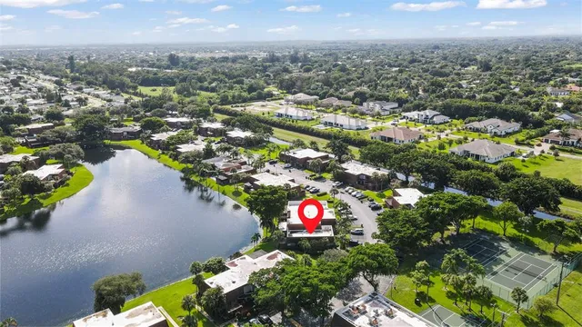 an aerial view of residential house with outdoor space and trees all around