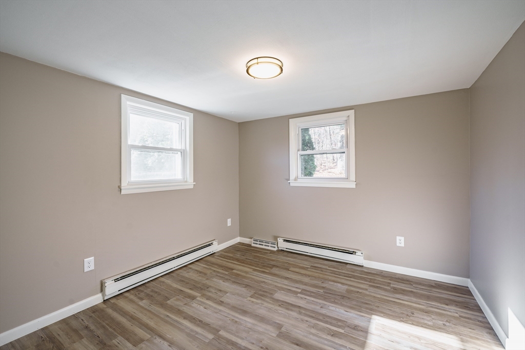 172 Bumstead Road Monson, MA 01057 - Photo 19 of 36 an empty room with wooden floor and windows