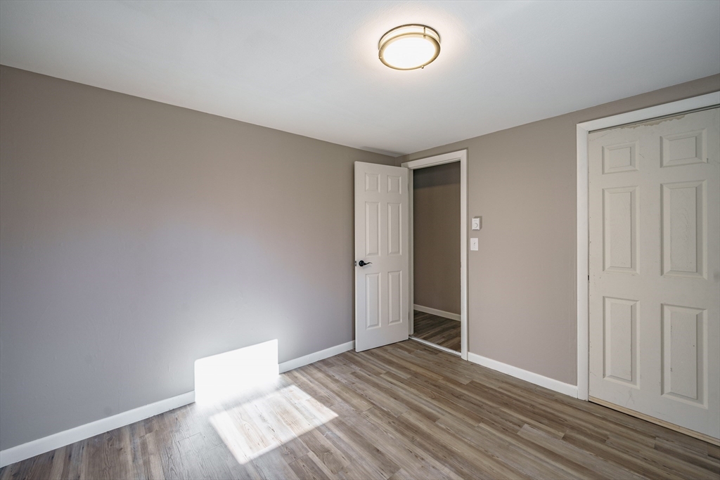 172 Bumstead Road Monson, MA 01057 - Photo 21 of 36 an empty room with wooden floor and windows