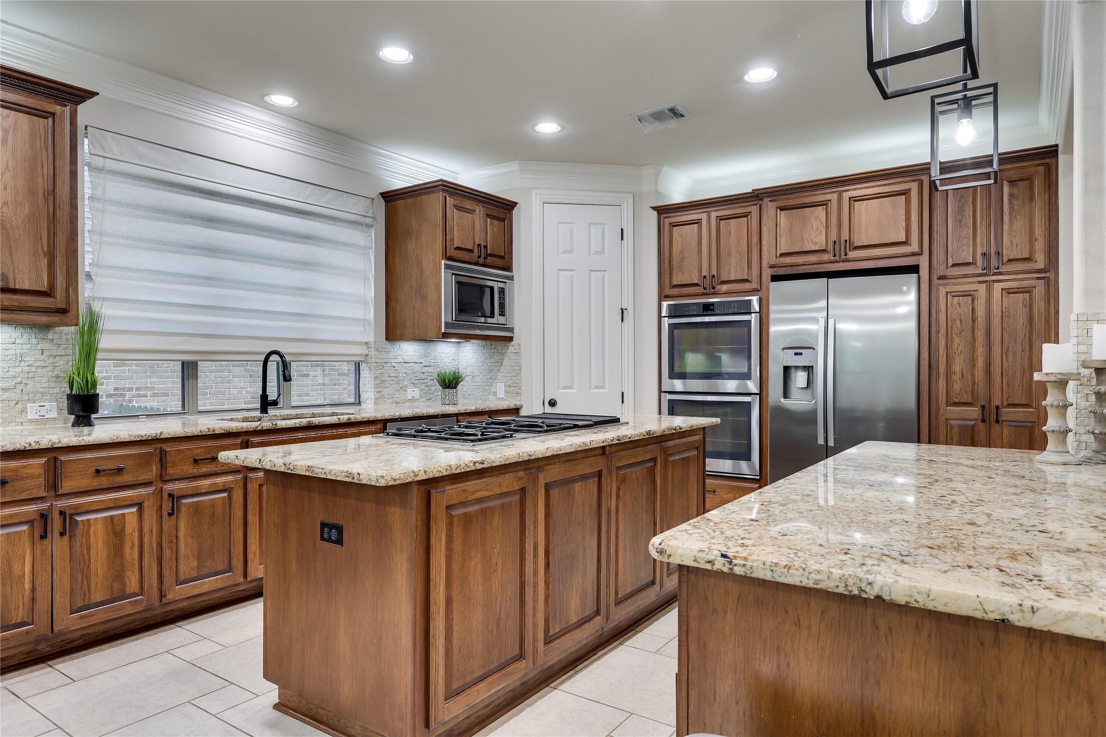 408 Ridgetop Bend Cedar Park, TX 78613 - Photo 9 of 40 A well-appointed kitchen features rich wood cabinetry, granite countertops, and modern stainless steel appliances.