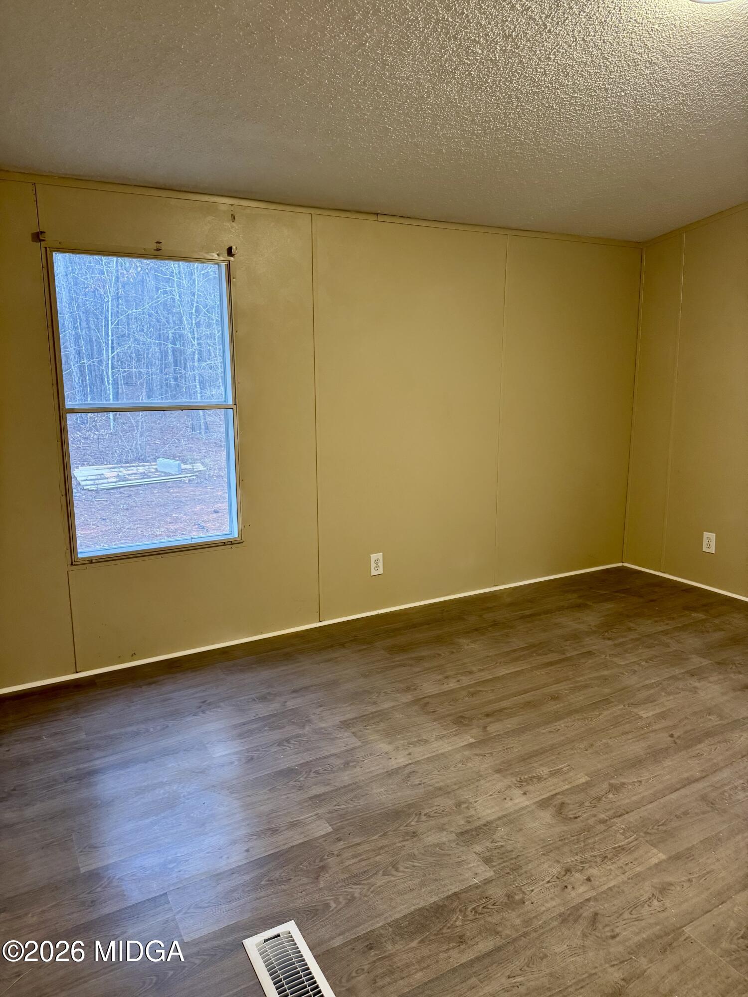 197 Cherokee Trail Forsyth, GA 31029 - Photo 6 of 9 a view of an empty room with wooden floor and a window
