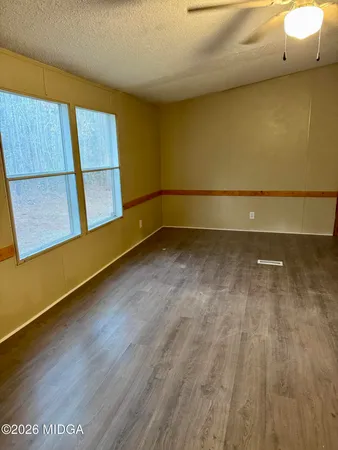 a view of a room with wooden floor and a window