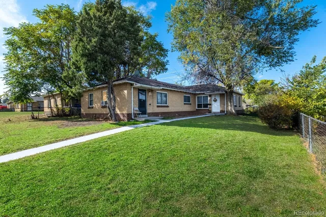 a front view of a house with yard and green space