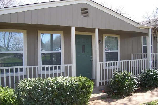 a view of a house with a small yard and wooden floor and fence