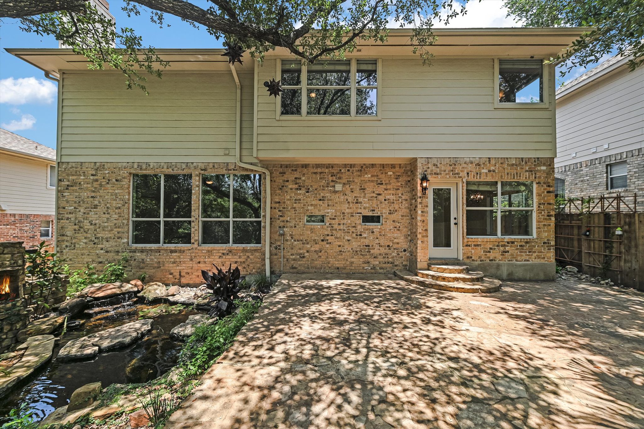 2849 Grimes Ranch Road Austin, TX 78732 - Photo 29 of 31 A tranquil backyard retreat featuring a cascading waterfall and shaded patio.