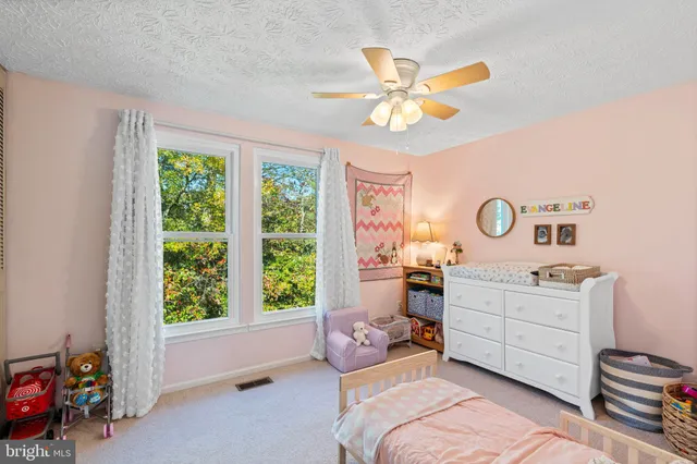a bedroom with a bed and a chandelier fan