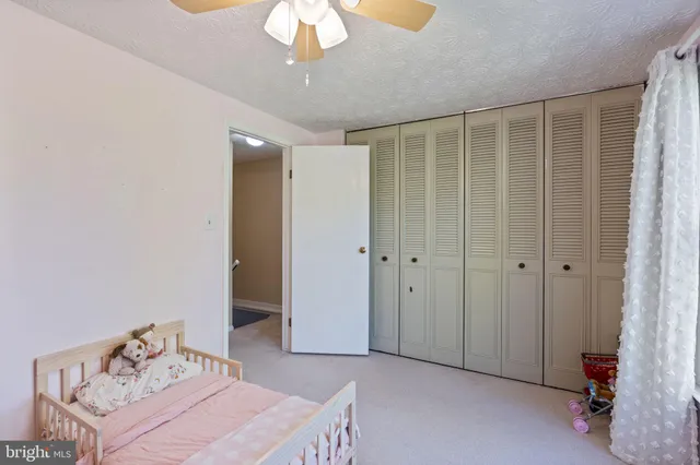 a bedroom with a bed and a chandelier fan