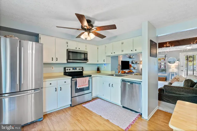 a kitchen with a refrigerator a sink and white cabinets