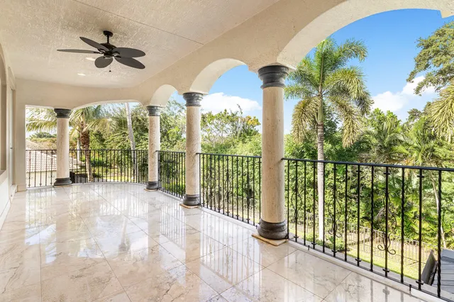 an aerial view of a house with yard and trees in the background