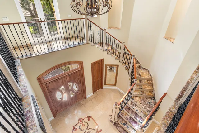 a front view of a house with garden and trees