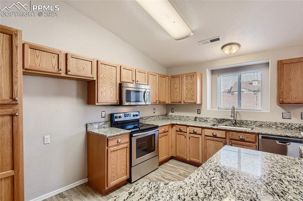 3780 Riviera Grove, Unit 204 Colorado Springs, CO 80922 - Photo 13 of 33 a kitchen with stainless steel appliances granite countertop a stove sink and cabinets