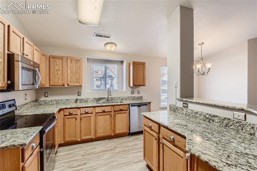3780 Riviera Grove, Unit 204 Colorado Springs, CO 80922 - Photo 14 of 33 a large kitchen with a sink and cabinets