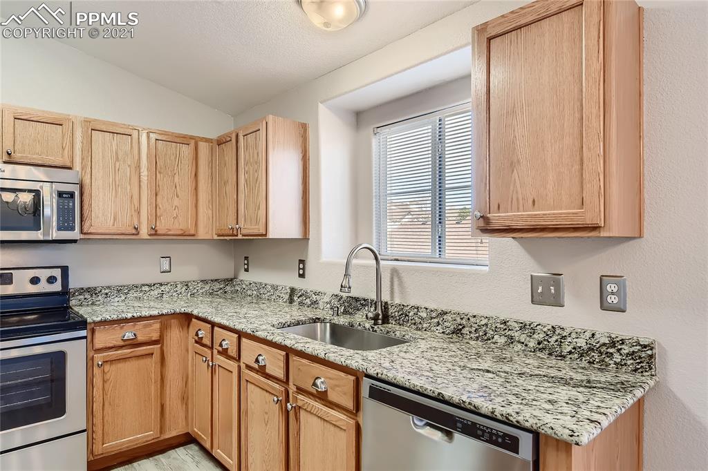 3780 Riviera Grove, Unit 204 Colorado Springs, CO 80922 - Photo 16 of 33 a kitchen with stainless steel appliances granite countertop a sink stove and cabinets