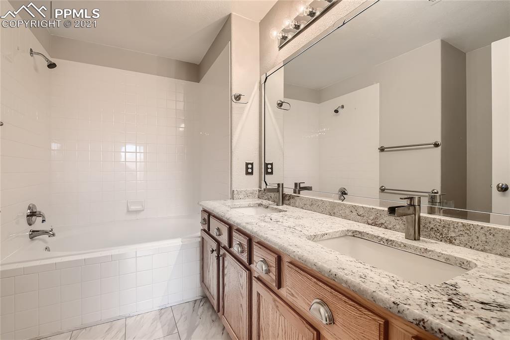 3780 Riviera Grove, Unit 204 Colorado Springs, CO 80922 - Photo 22 of 33 a bathroom with a granite countertop sink and a mirror