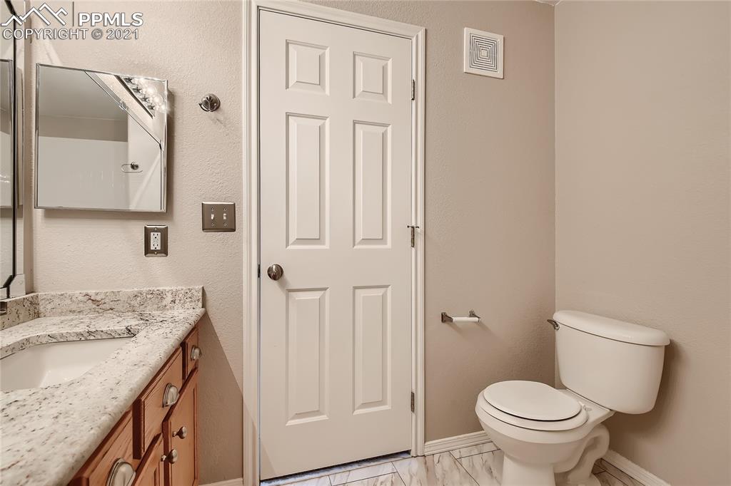 3780 Riviera Grove, Unit 204 Colorado Springs, CO 80922 - Photo 23 of 33 a bathroom with a granite countertop sink toilet and shower