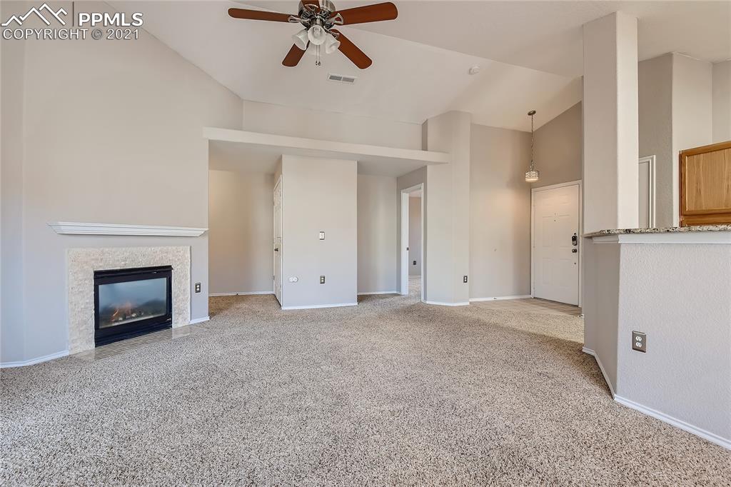 3780 Riviera Grove, Unit 204 Colorado Springs, CO 80922 - Photo 7 of 33 a view of empty room with fireplace and wooden floor