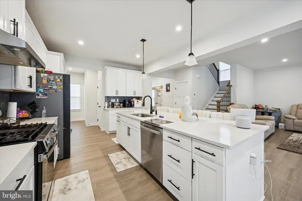 a kitchen with kitchen island a sink a stove and a refrigerator