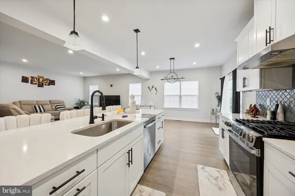 a kitchen with sink stove and cabinets