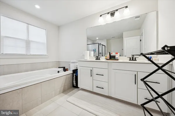 a bathroom with a tub sink and mirror
