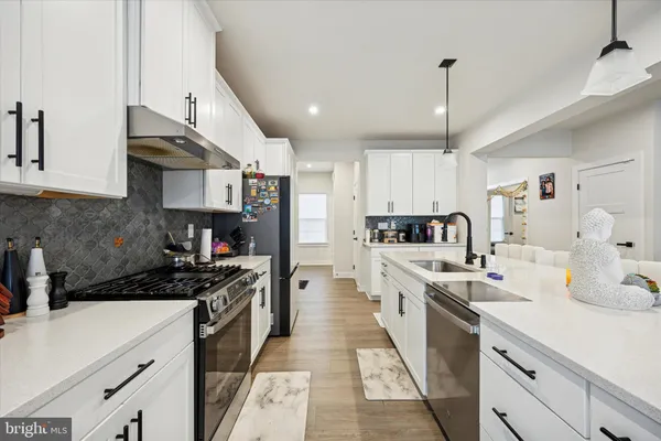 a kitchen with stainless steel appliances a sink stove and refrigerator