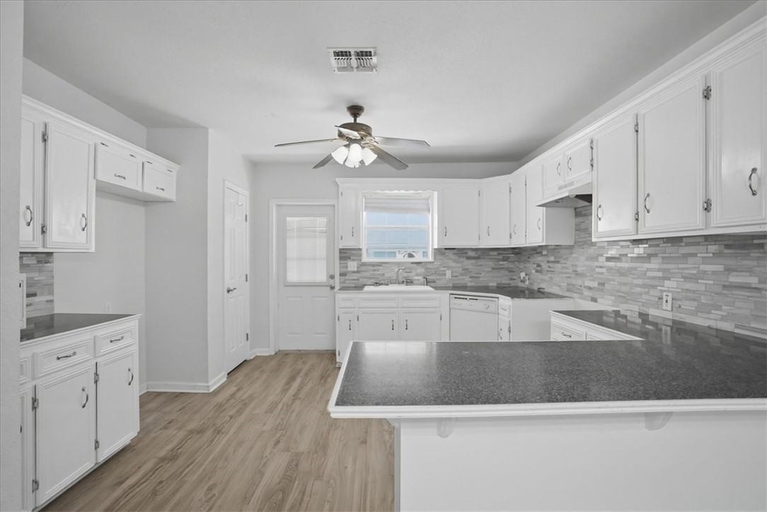 1601 Owens Avenue Three Rivers, TX 78071 - Photo 11 of 34 a large kitchen with cabinets wooden floor and a sink