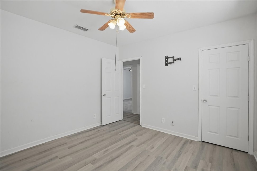 1601 Owens Avenue Three Rivers, TX 78071 - Photo 20 of 34 an empty room with wooden floor fan and windows