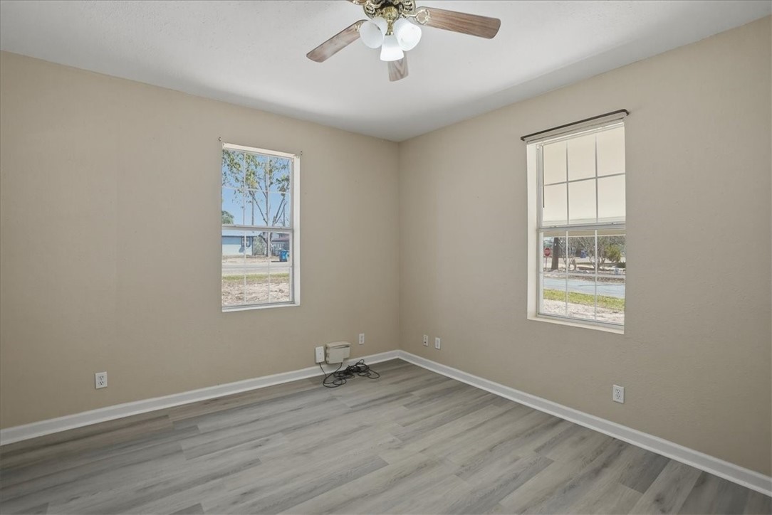 1601 Owens Avenue Three Rivers, TX 78071 - Photo 21 of 34 a view of an empty room with wooden floor and a window