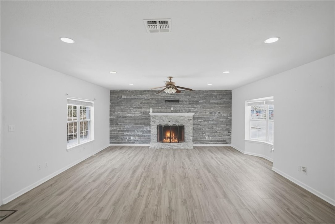 1601 Owens Avenue Three Rivers, TX 78071 - Photo 3 of 34 an empty room with wooden floor fireplace and windows
