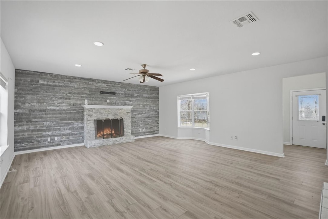1601 Owens Avenue Three Rivers, TX 78071 - Photo 6 of 34 an empty room with wooden floor fireplace and windows