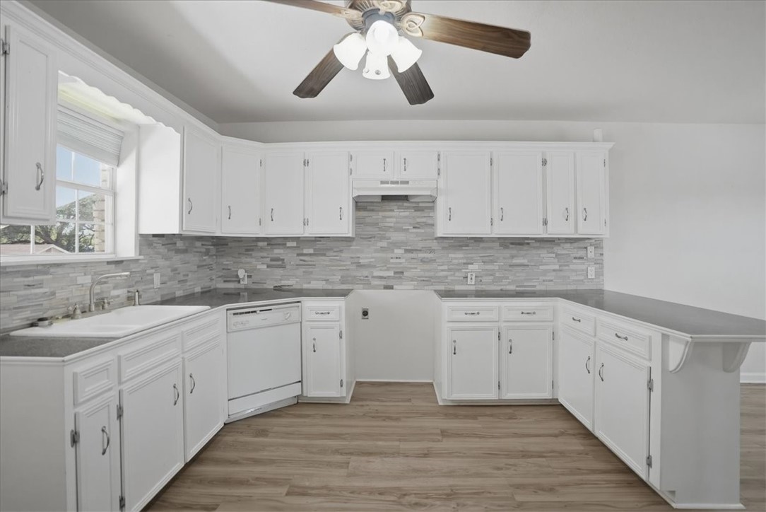 1601 Owens Avenue Three Rivers, TX 78071 - Photo 10 of 34 a kitchen with granite countertop white cabinets white stainless steel appliances with a sink and dishwasher