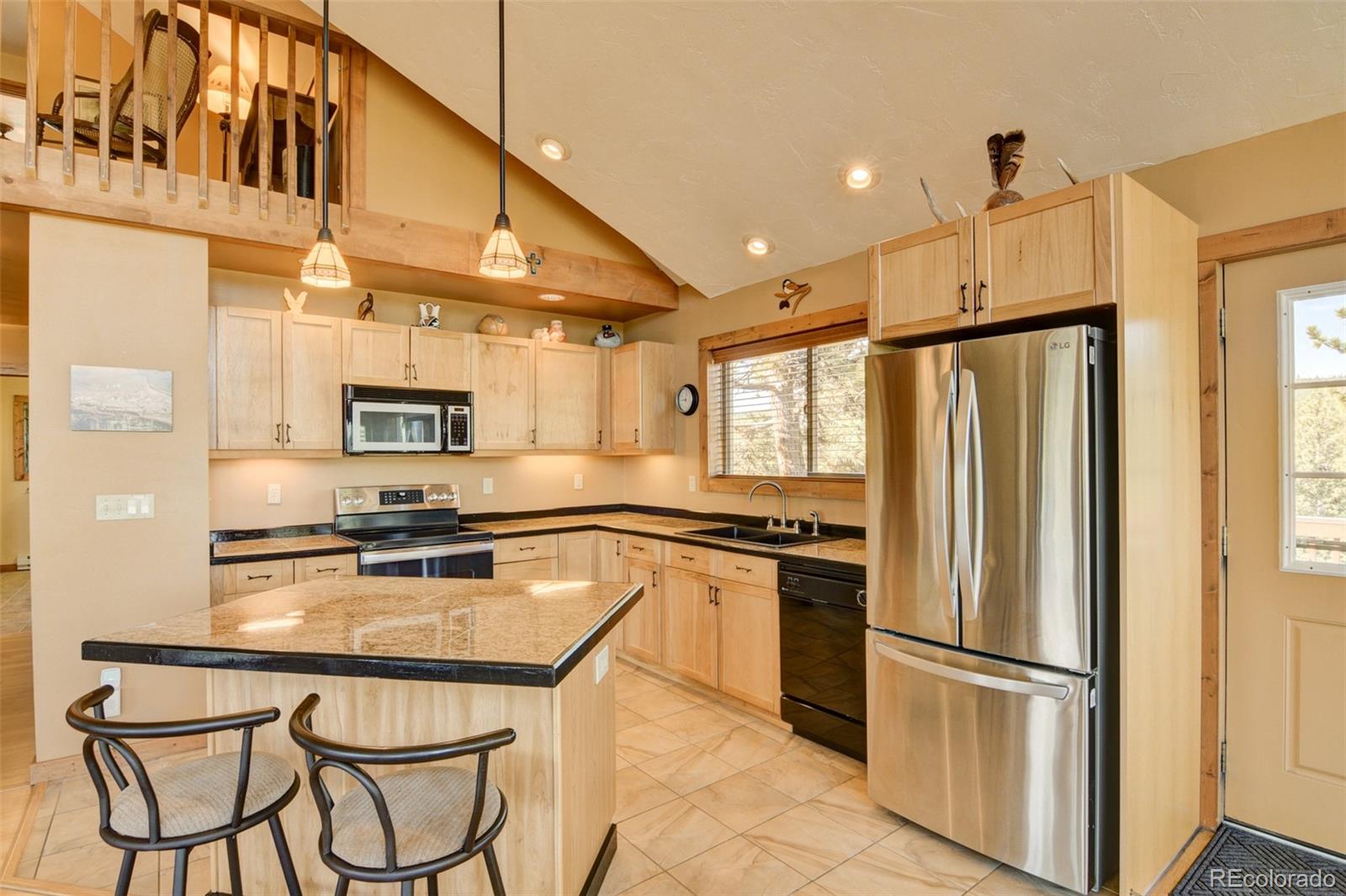 3296 Singletree Road Hartsel, CO 80449 - Photo 25 of 50 a kitchen with stainless steel appliances a refrigerator a stove a sink dishwasher and white cabinets with wooden floor