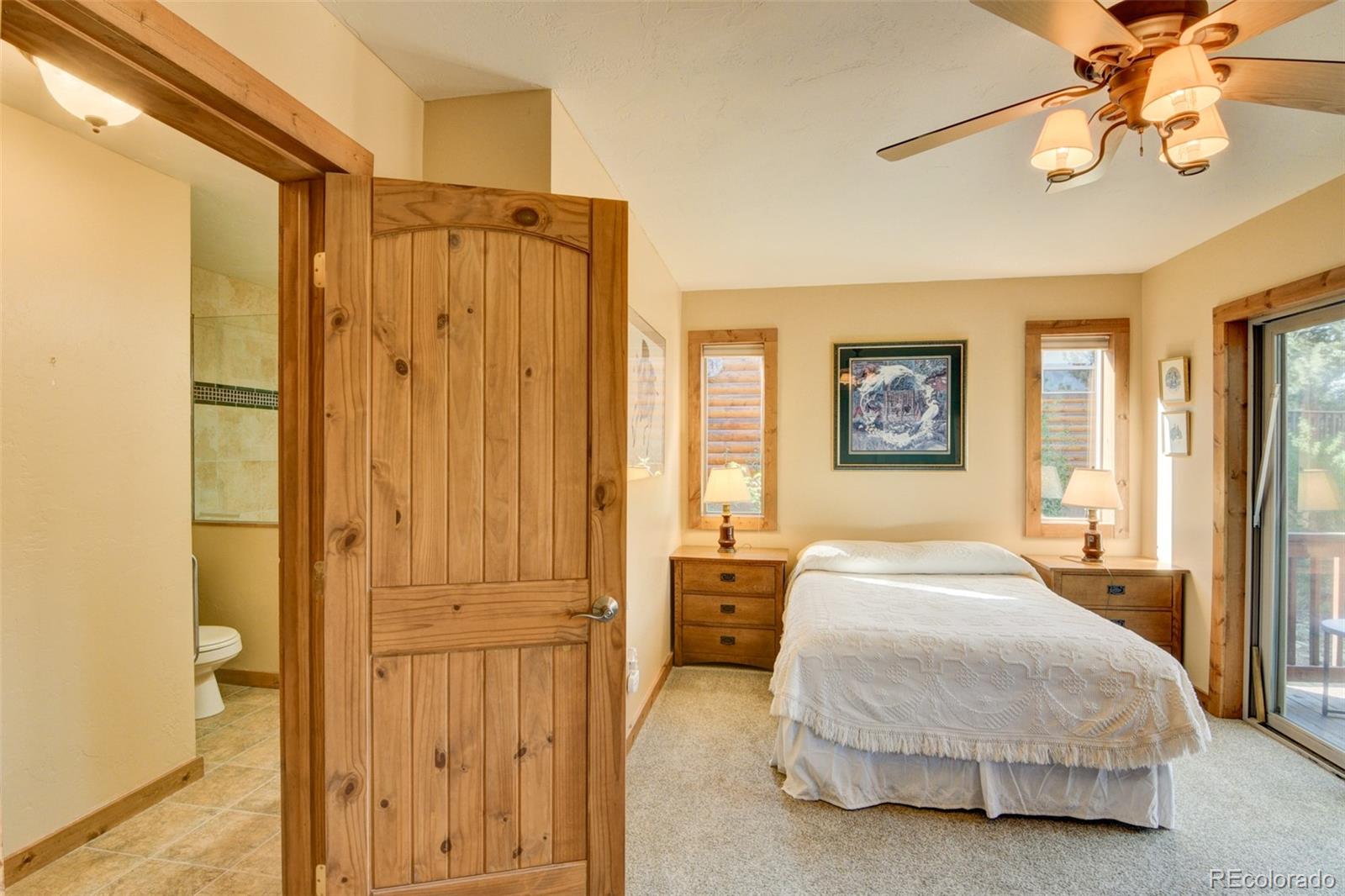 3296 Singletree Road Hartsel, CO 80449 - Photo 31 of 50 a spacious bedroom with a bed and a chandelier