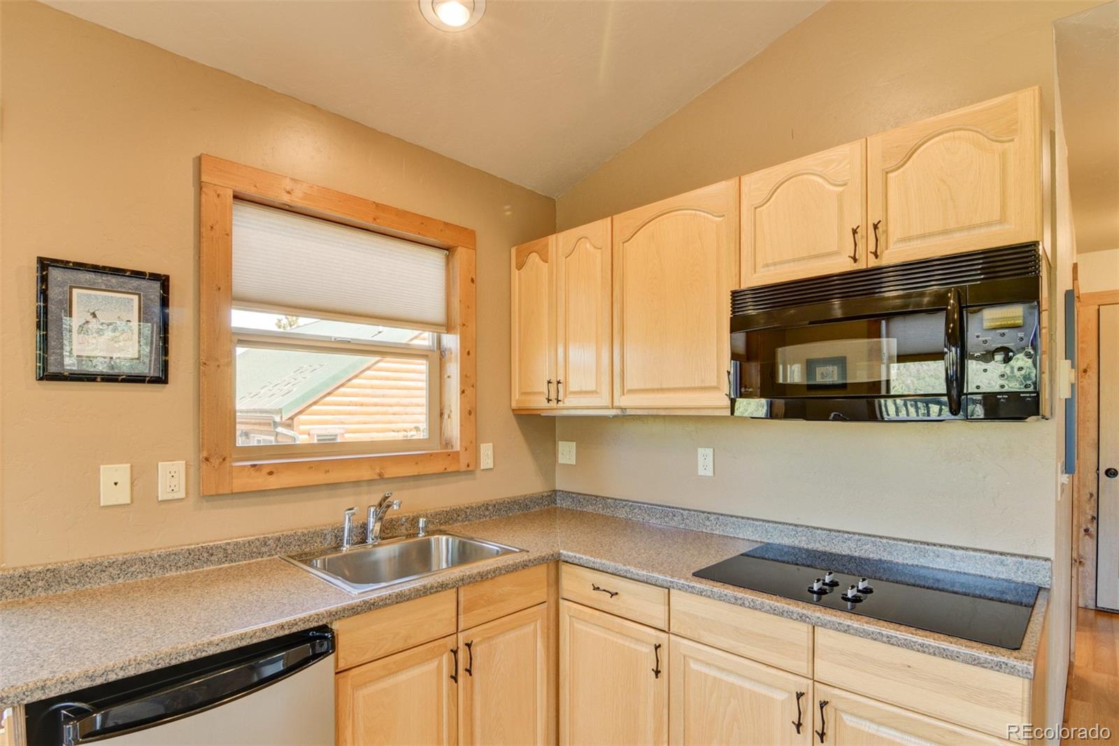 3296 Singletree Road Hartsel, CO 80449 - Photo 45 of 50 a kitchen with granite countertop a sink a stove and cabinets