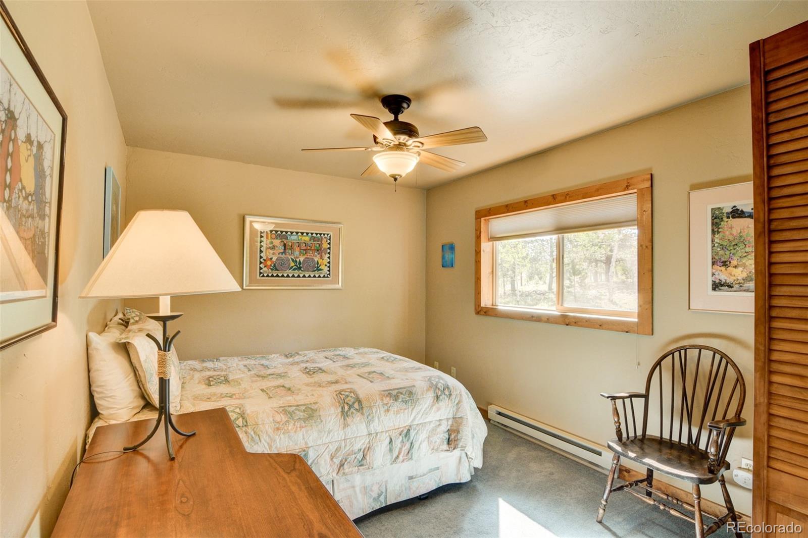 3296 Singletree Road Hartsel, CO 80449 - Photo 46 of 50 a bedroom with a bed and a chandelier