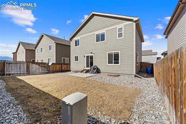 6170 Pilgrimage Road Colorado Springs, CO 80925 - Photo 21 of 28 Back of property with a patio area, a fenced backyard, and central AC unit