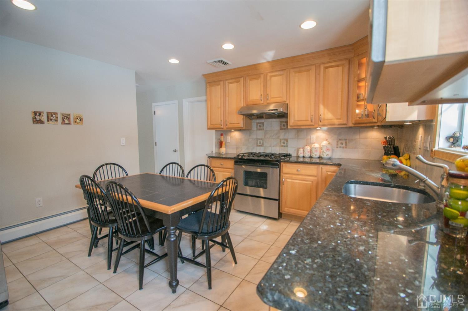 9 Library Place Edison, NJ 08820 - Photo 17 of 44 a kitchen with granite countertop kitchen island stainless steel appliances a sink a stove a table and chair
