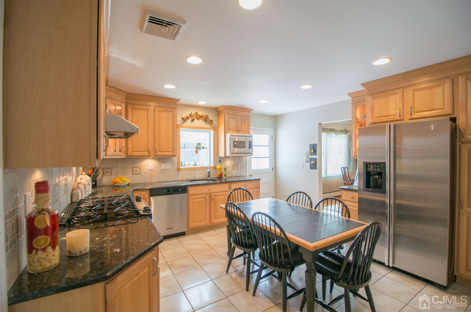 9 Library Place Edison, NJ 08820 - Photo 20 of 44 a kitchen with stainless steel appliances granite countertop a table chairs sink refrigerator and microwave