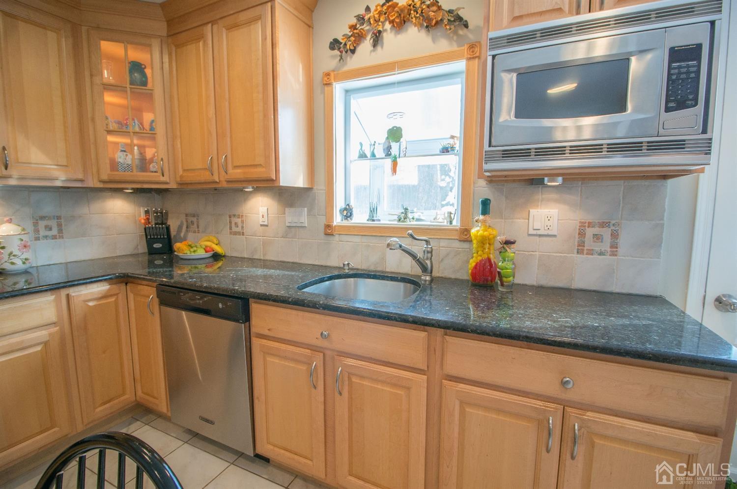9 Library Place Edison, NJ 08820 - Photo 21 of 44 a kitchen with stainless steel appliances granite countertop a sink a microwave cabinets and a window