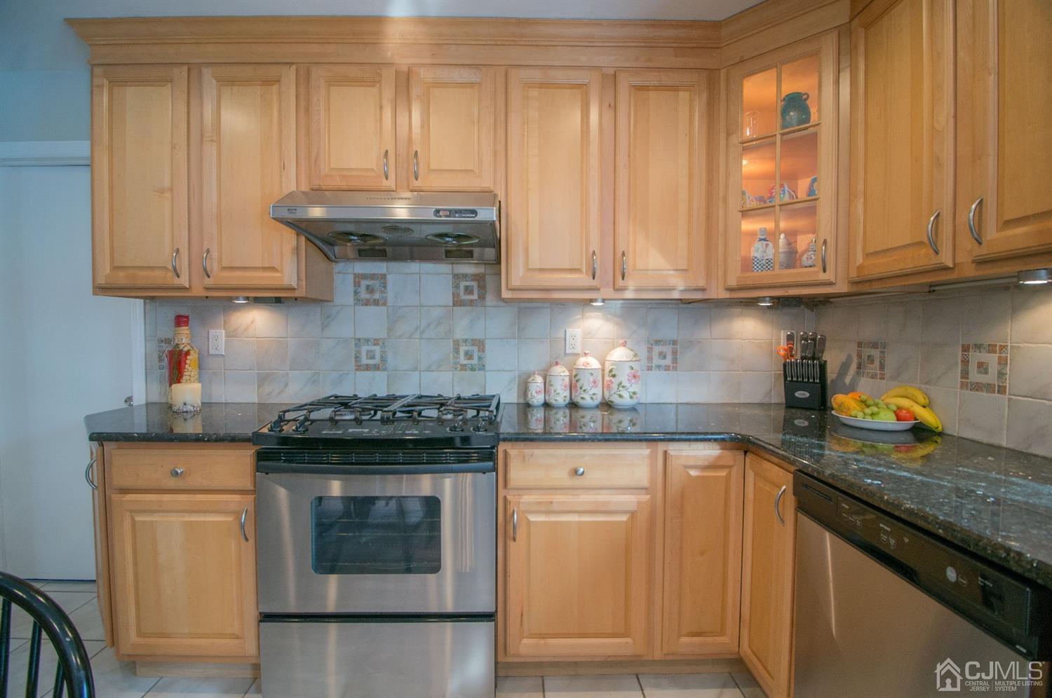 9 Library Place Edison, NJ 08820 - Photo 22 of 44 a kitchen with granite countertop wooden cabinets and a stove top oven