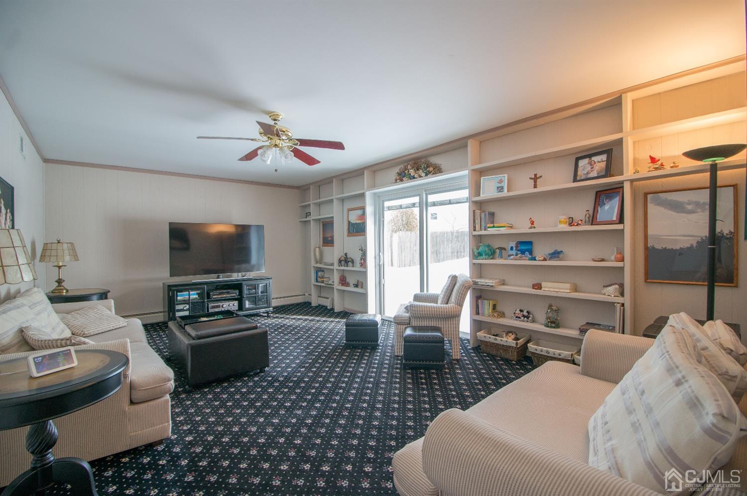9 Library Place Edison, NJ 08820 - Photo 23 of 44 a living room with furniture a flat screen tv and floor to ceiling window