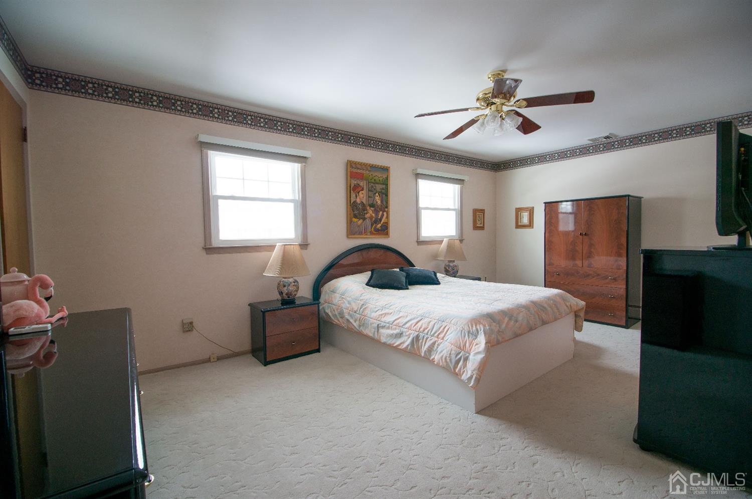 9 Library Place Edison, NJ 08820 - Photo 35 of 44 a bedroom with a large bed and a chandelier