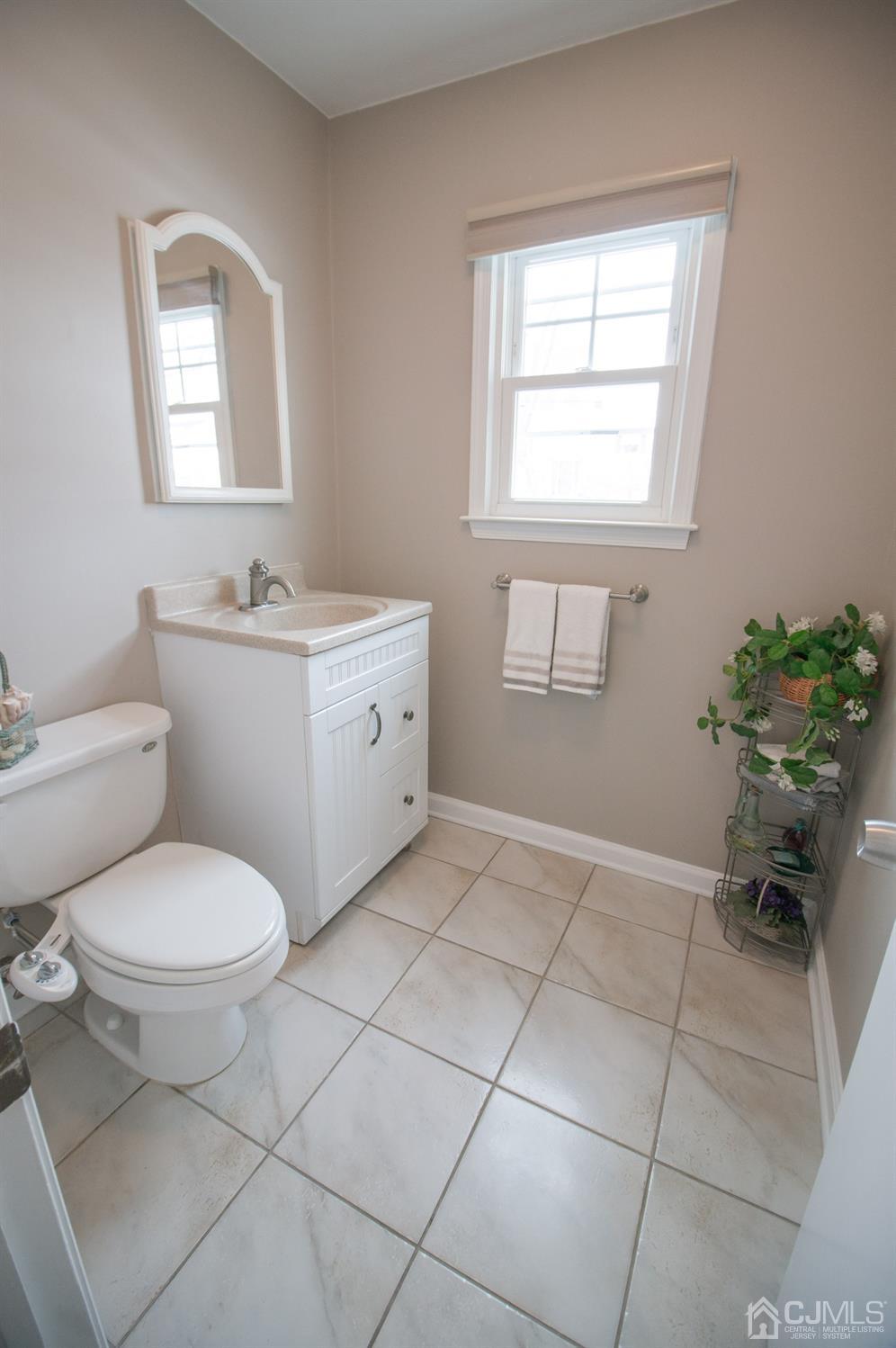 9 Library Place Edison, NJ 08820 - Photo 9 of 44 a bathroom with a toilet sink and mirror