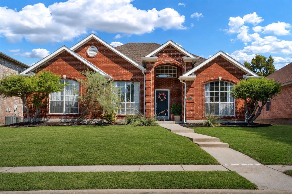 11414 Promenade Road Frisco, TX 75035 - Photo 2 of 24 Red brick facade with arched windows, a dark entry door, and a concrete walk