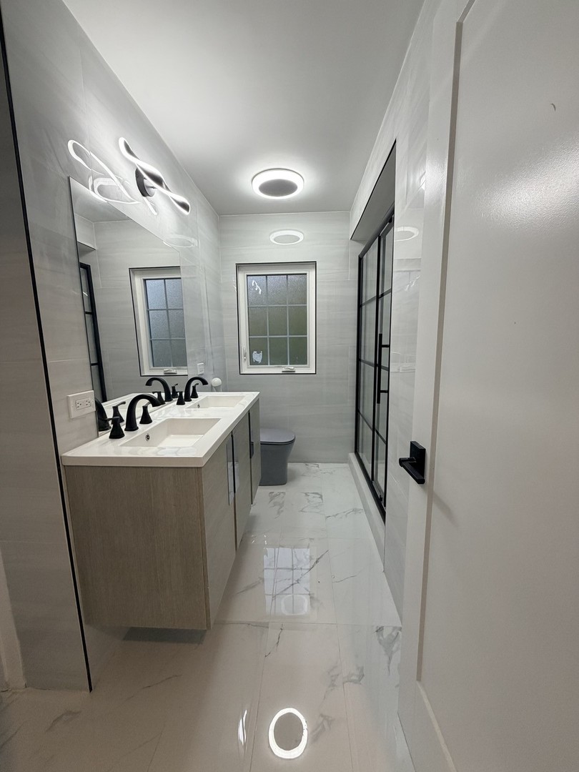 3024 West Fargo Avenue Chicago, IL 60645 - Photo 19 of 38 a room with a sink a washer and dryer