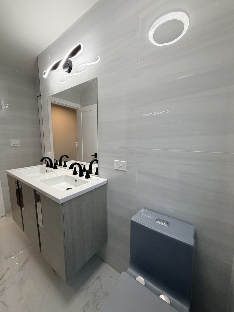 3024 West Fargo Avenue Chicago, IL 60645 - Photo 21 of 38 a bathroom with a sink vanity and mirror