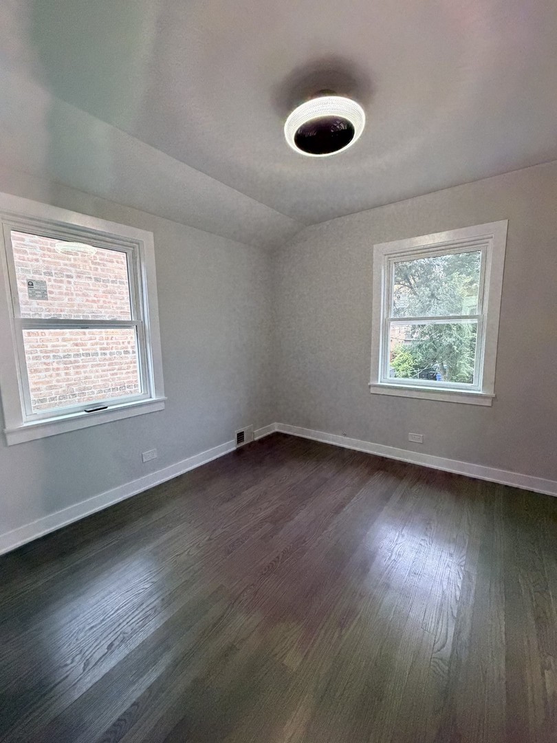 3024 West Fargo Avenue Chicago, IL 60645 - Photo 25 of 38 a view of an empty room with wooden floor and a window