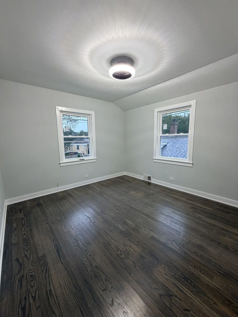 3024 West Fargo Avenue Chicago, IL 60645 - Photo 27 of 38 a view of an empty room with wooden floor and a window